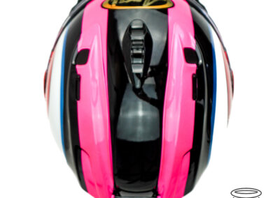 A top view of Paul Cassidy's Isle of Man TT 2024 helmet - with black and fluorescent pink stripes with a gold arai logo