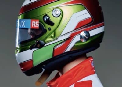 SIDE PROFILE OF A CUSTOM PAINTED RACING HELMET BY X-Paint created for Caleb Mcduff featuring poison green candy apple red and white graphics with a personalised racing design this is a screenshot from Caleb's instagram profile