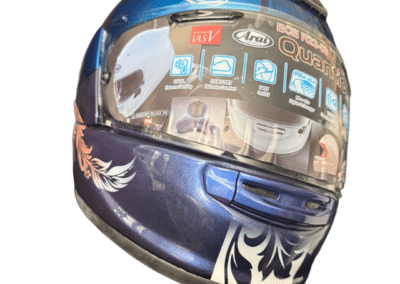 Side view of custom painted Arai Quantic helmet showing blush and white feather airbrush detail with gold phoenix, X-Paint signature