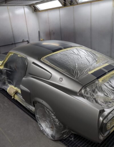 Pictured is a classic 60's Ford Mustang stripped and in the spray booth at Sandown Motors getting completely re sprayed in a shimmiring silver basecoat