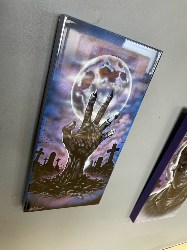 airbrush artwork of a zombie hand rising from the grave